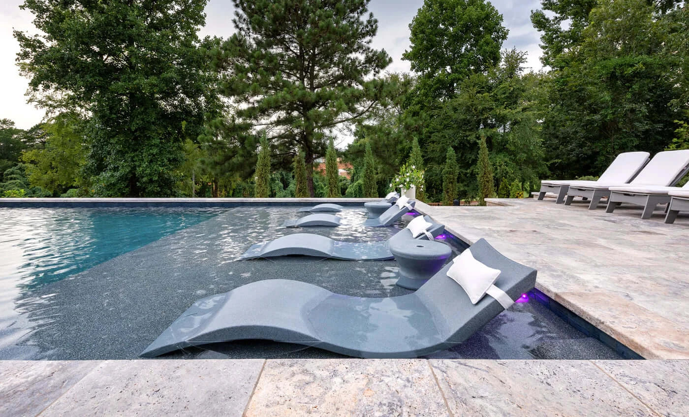 Designed for tanning ledges, baja shelves, or sun shelves with water depths up to 9 inches, this set includes two Signature In-Pool Chaise Loungers, two plush Headrest Pillows, and a versatile Side Table.