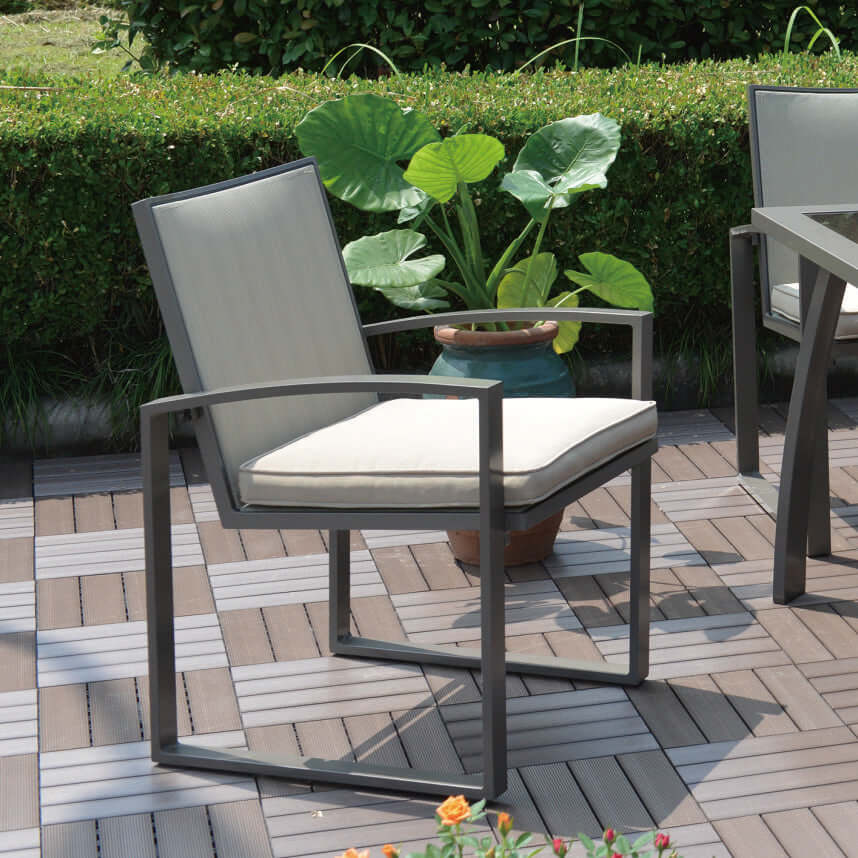 Six outdoor dining armchairs made with powder-coated aluminum frames and tan polyester fabric cushions or upgrade to Sunbrella fabric