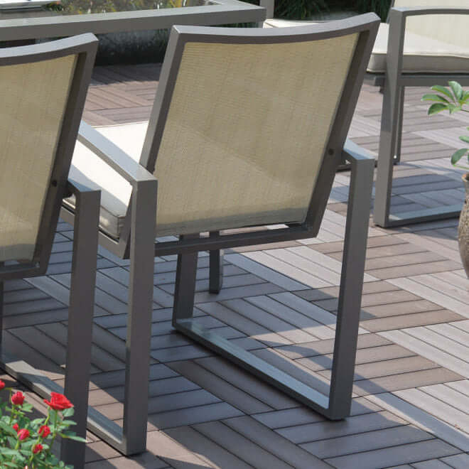 Six outdoor dining armchairs made with powder-coated aluminum frames and tan polyester fabric cushions or upgrade to Sunbrella fabric