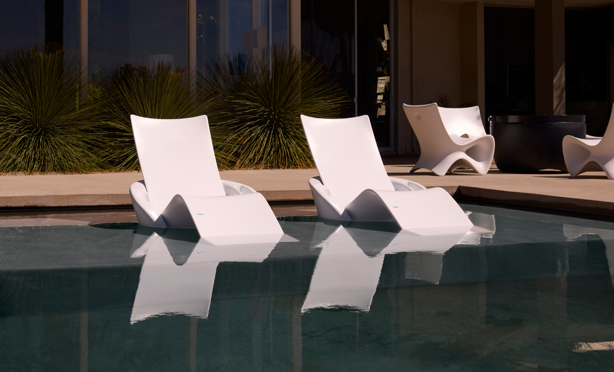 Two white Autograph Chaise Armrest Consoles on an in-pool tanning ledge