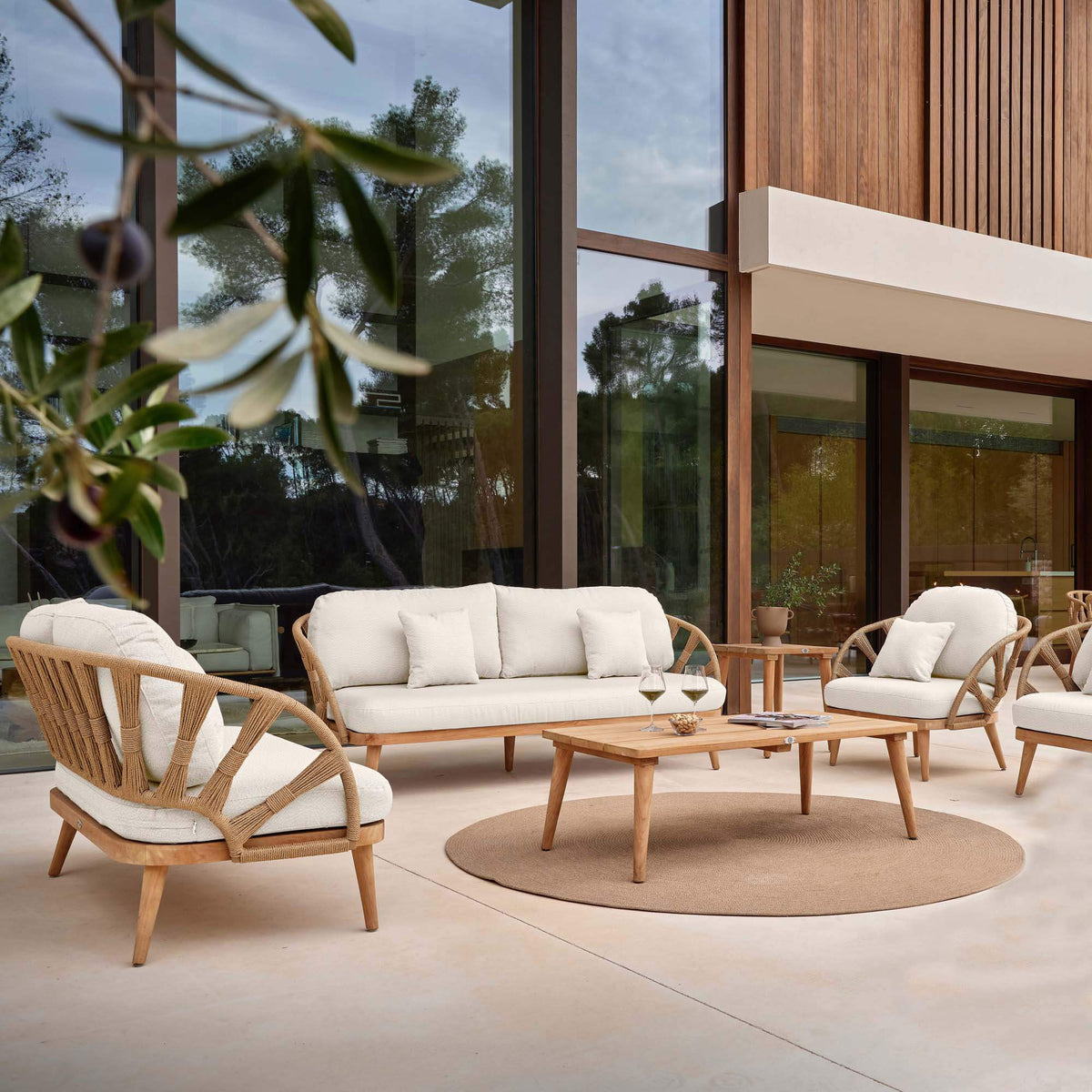 7-piece outdoor seating set Includes: (3) Armchairs; (2) Sofas; (1) Coffee Table; (1) Side Table made from teak wood and polystrand rami natural rope