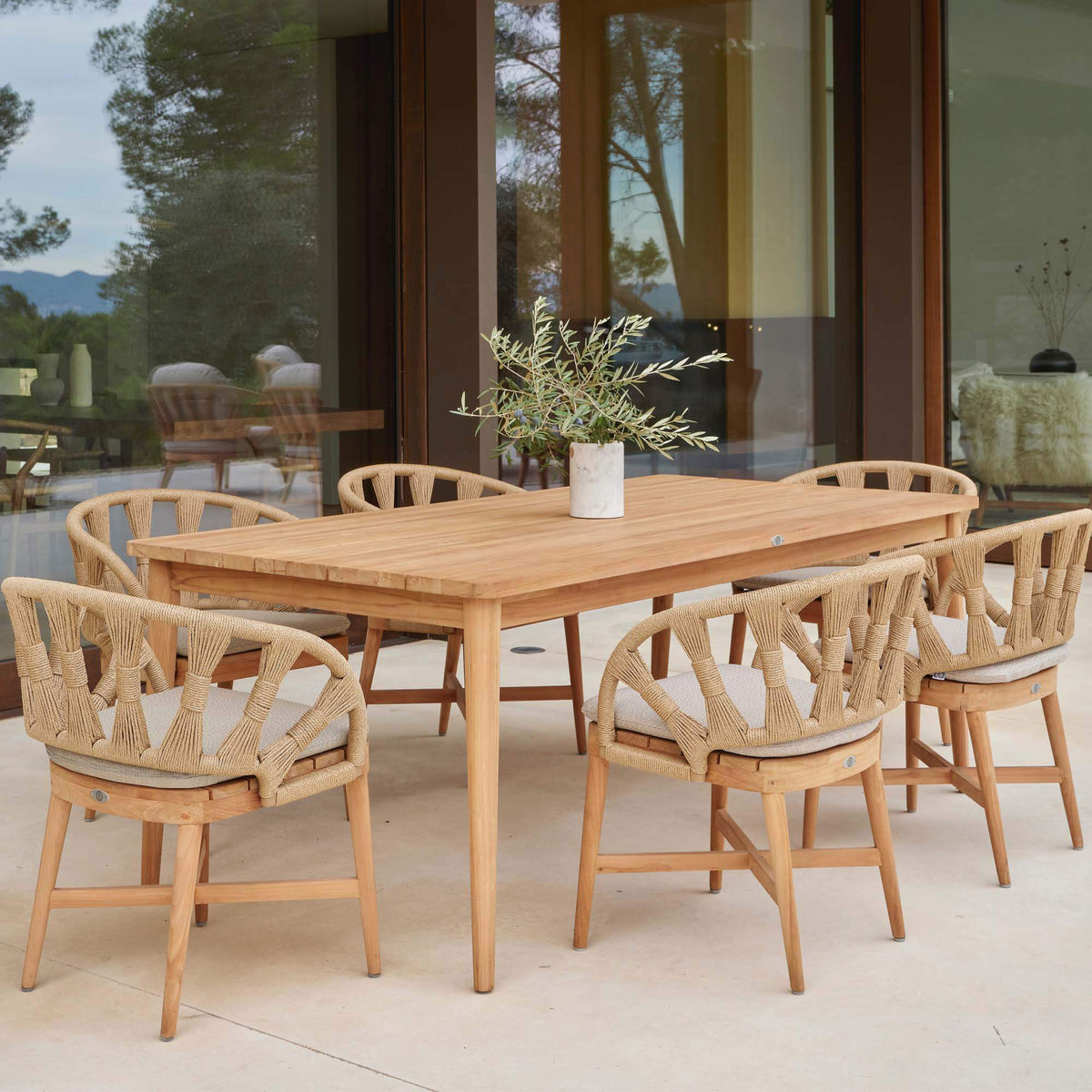 Krabi 7-Piece Rectangular Outdoor Dining Set features an elegant rope-wrapped frame, sculpted curves, and a warm teak base.