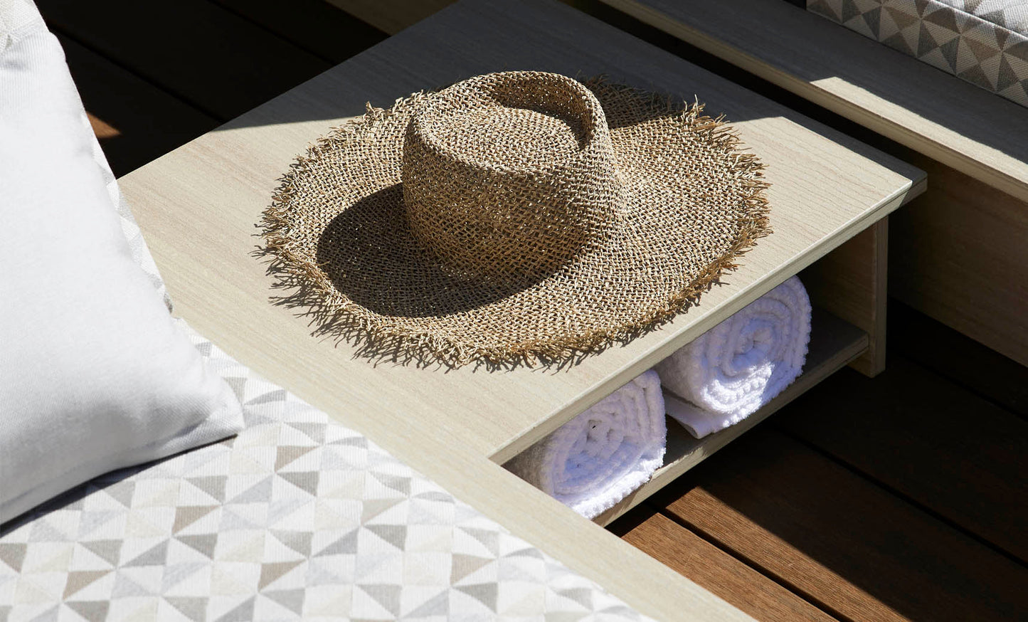 Echo Side Table with a hat on top and rolled towels on the lower shelf