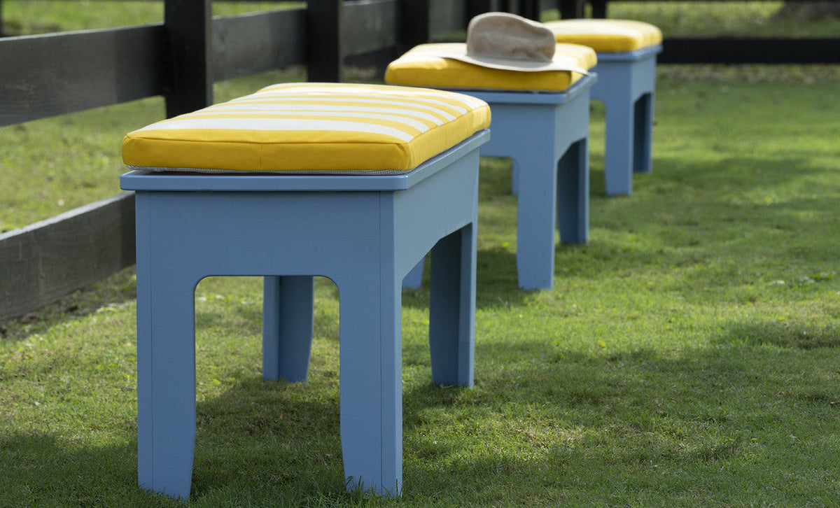 Blue Mainstay Dining Benches with striped cushions in a garden
