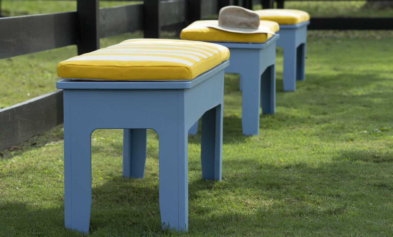 Blue Mainstay Dining Benches with striped cushions in a garden