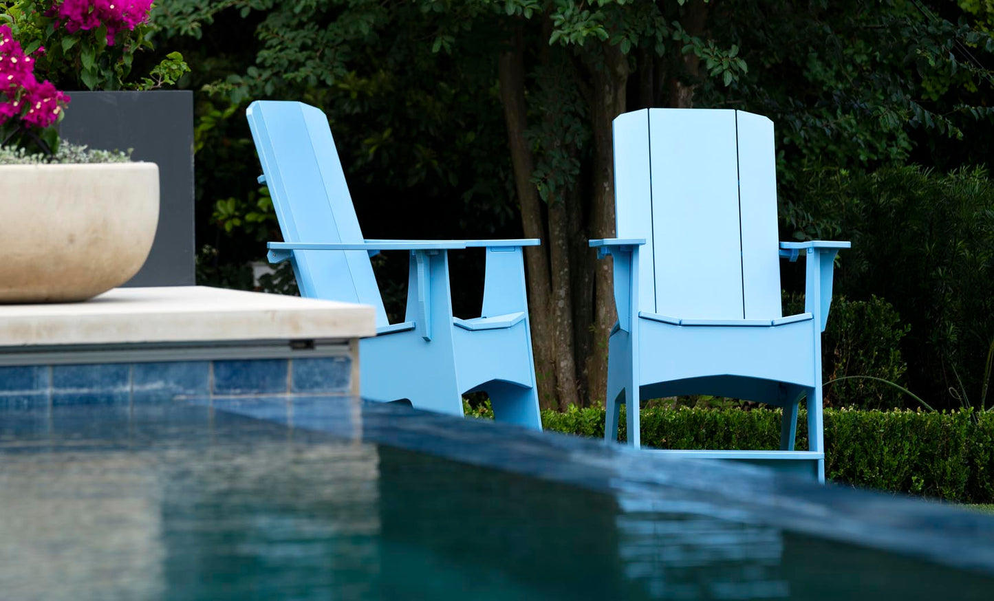 Sky Blue Mainstay Adirondack Tall chairs poolside among greenery