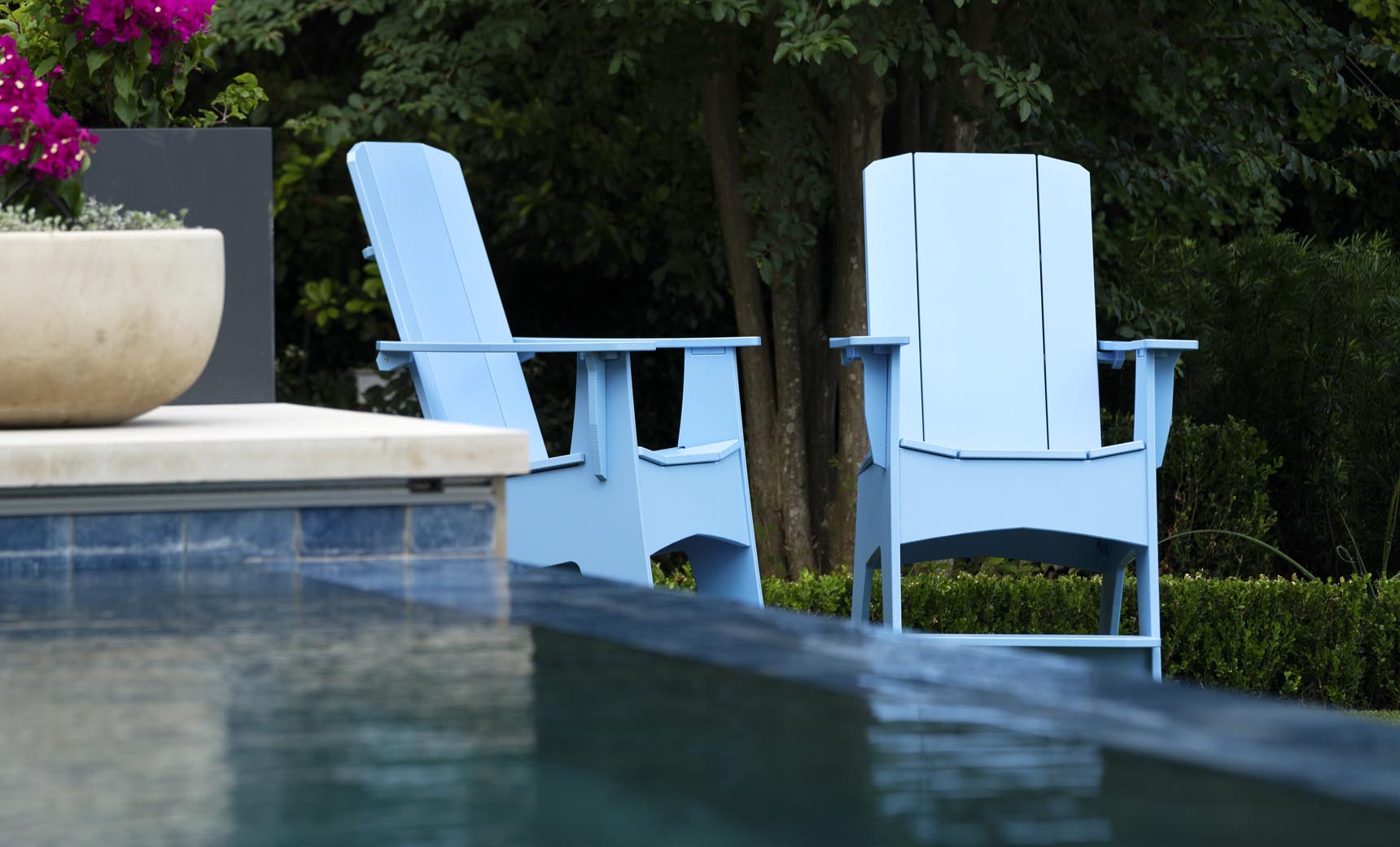 Sky Blue Mainstay Adirondack Tall chairs poolside among greenery