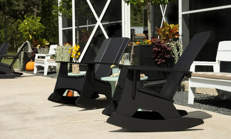 Black Adirondack chairs on a patio with outdoor decor