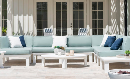 Mainstay Round Coffee Table on a modern patio with a light blue sectional