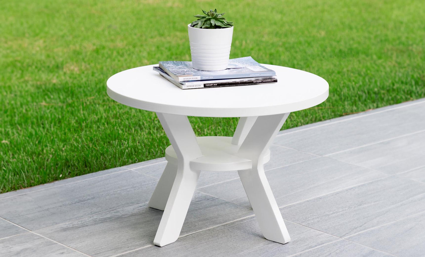 Mainstay Round Side Table on a tiled patio holding a small planter and magazines