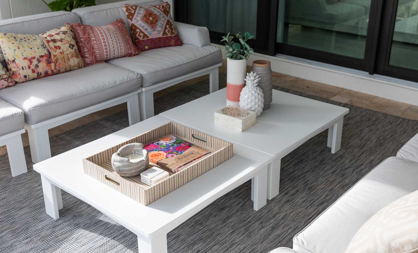 Mainstay Square Coffee Table with a tray and plant in a bright outdoor lounge
