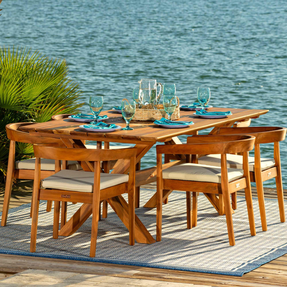 Panama Jack 7-piece outdoor rectangular dining table set made with Grade-A teak wood for a natural wood finish with cushions