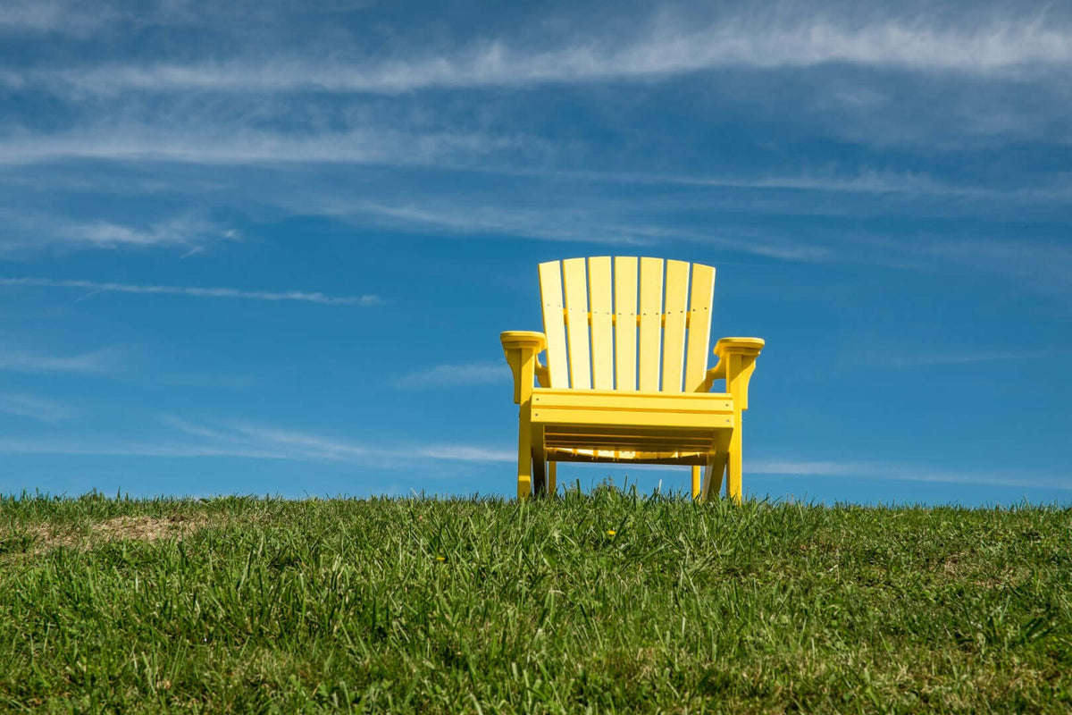 LuxCraft Deluxe Adirondack Chair in Yellow styled for patio lounging — 20-year poly durability