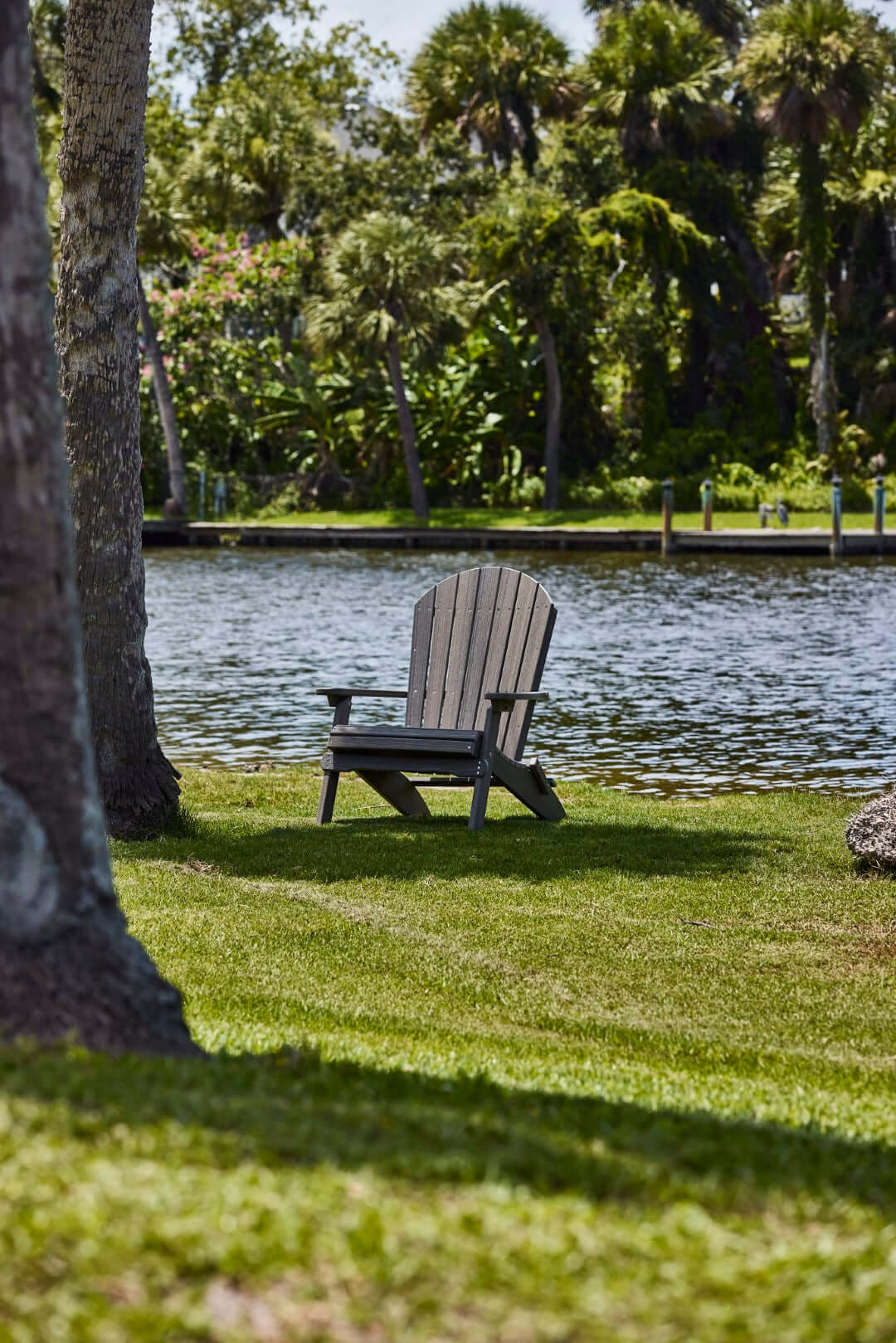 LuxCraft Folding Adirondack Chair in Coastal Gray styled for patio lounging — 20-year poly durability