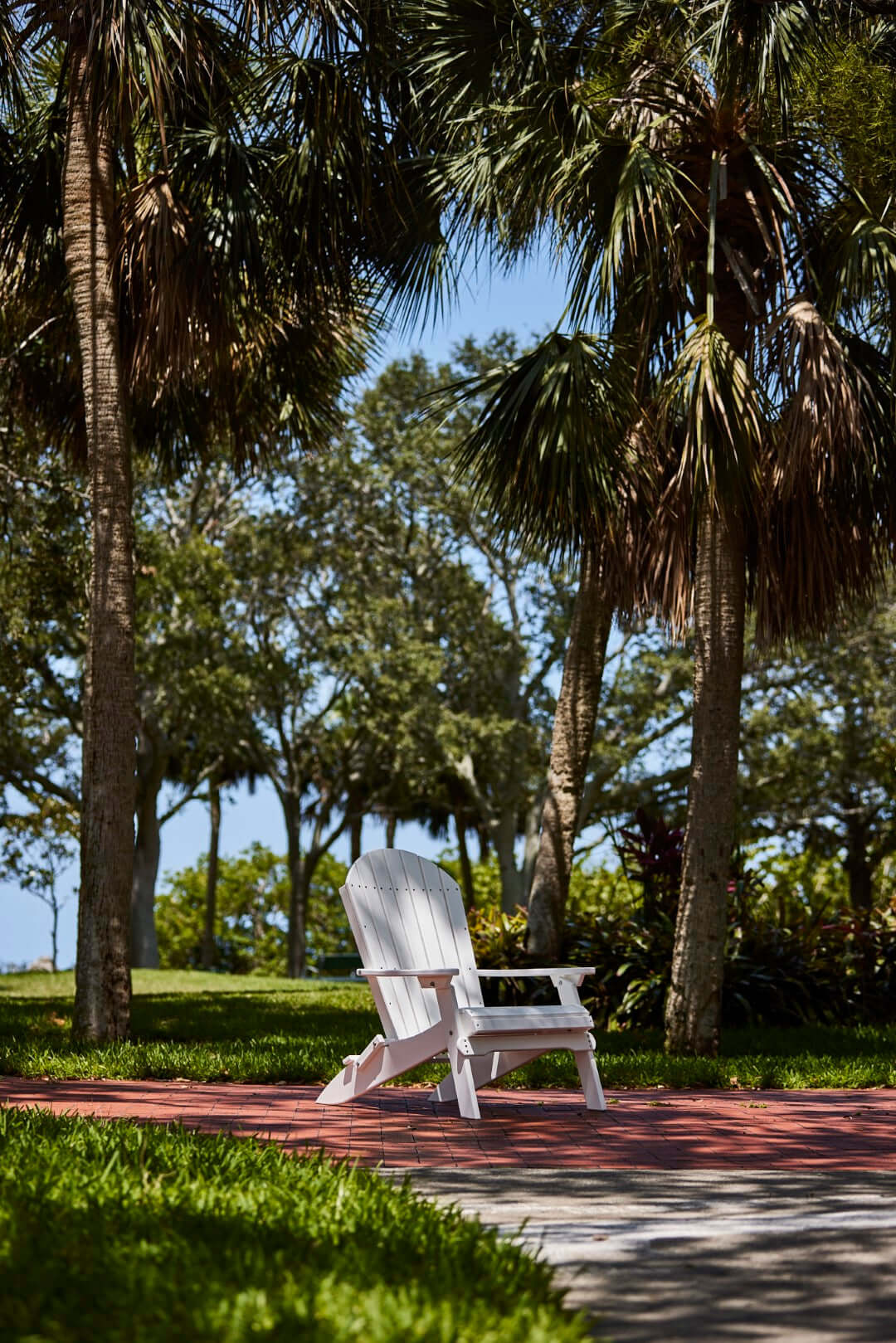 LuxCraft Folding Adirondack Chair in White positioned for backyard relaxation — all-weather outdoor build