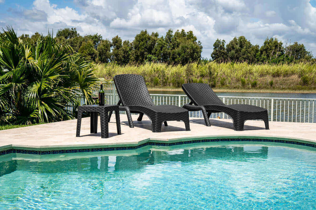 Black outdoor 3-piece chaise lounger set includes 2 stackable chaise loungers and an end table