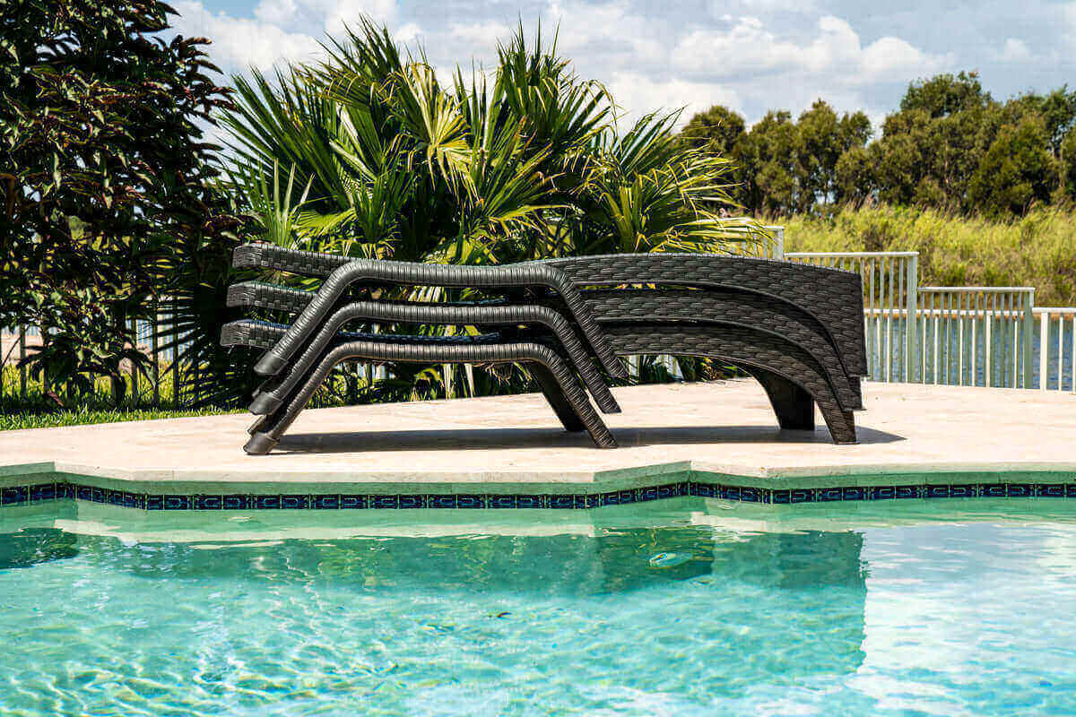 Black outdoor 3-piece chaise lounger set includes 2 stackable chaise loungers and an end table