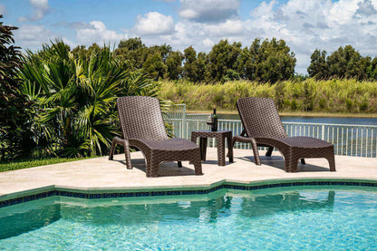 Brown outdoor 3-piece chaise lounger set includes 2 stackable chaise loungers and an end table