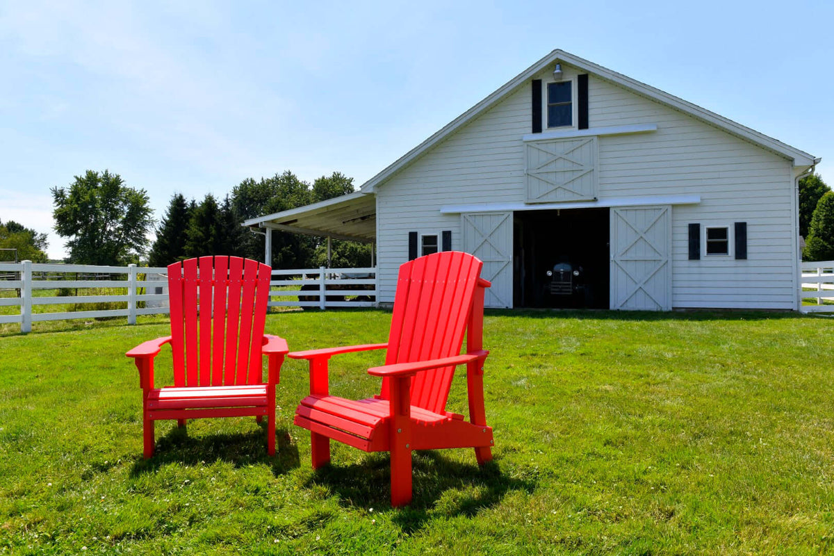 LuxCraft Royal Adirondack Chair in Red positioned for backyard relaxation — all-weather outdoor build