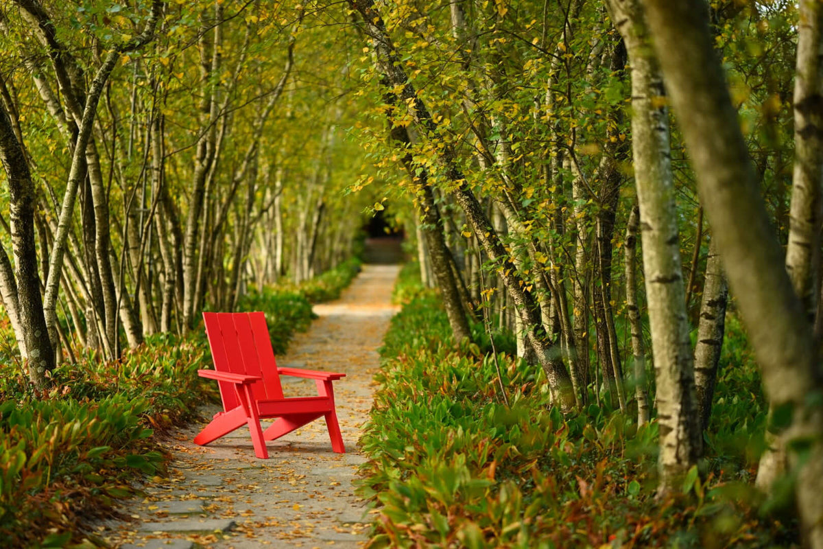 LuxCraft Urban Adirondack Chair in Red positioned for backyard relaxation — all-weather outdoor build